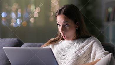 Surprised woman finding amazing news on laptop