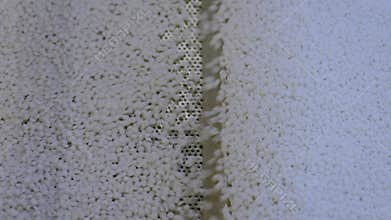 Recycled plastic granules on automatic conveyor belt - top view