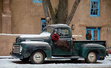 Old Ford Truck in front of a Santa Fe Adobe house at Christmas time