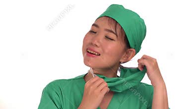 Young beautiful and happy Asian Chinese medicine doctor woman or hospital nurse in medical hat and scrub taking out surgery mask