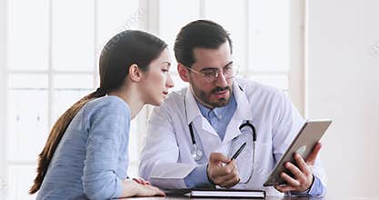 Doctor showing medical test results on digital tablet consulting patient