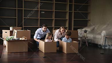 Cheerful parents and sibling kids competing in box racing