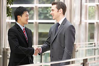 Two Businessmen Shaking Hands Outside Office