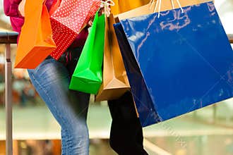 Two women shopping with bags in mall