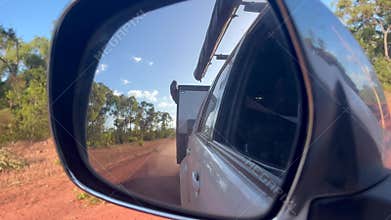 Mirror reflection of car towing an off road caravan
