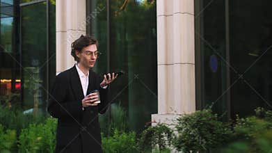 Business man speaking mobile phone onthe go to office outdoors. Smiling business people using digital devices while