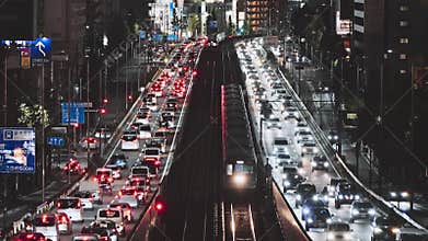 Car traffic transportation on elevated highway road, commuter subway train on railroad track at night in Japan.