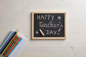 Top view of small black board with a Happy teachers day sign on it