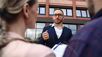 Fashion male real estate agent consulting couple buying flat city house with mortgage banking loan