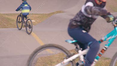 young bicycle riders on pumptrack in super slow motion