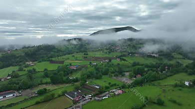 Aerial view of lush countryside with village, forest, and mountains, Infiesto, Asturia, Spain.