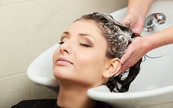 Hairstylist washing woman hair. Hairdressing beauty salon