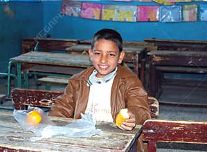 Young boy having his meal at school in class
