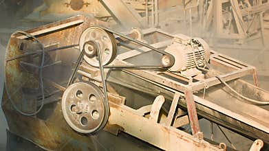 Industrial dusty old rusty machinery. Stone crusher in action