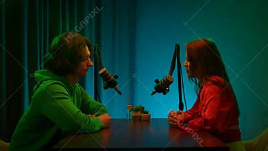 Engaging Dialogue Unfolds Between Two Influencers in a Creative Podcast Studio Setting