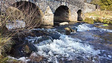 The East River Dart flowing below the road bridge at Postbridge on Dartmoor Devon UK