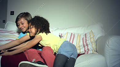 Two African American Children On Sofa Arguing Over TV Remote