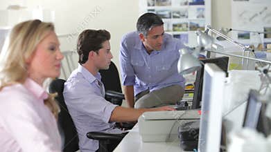 Workers At Desks In Busy Creative Office