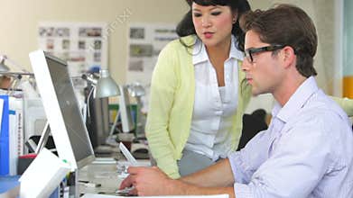Team Working At Desks In Busy Office