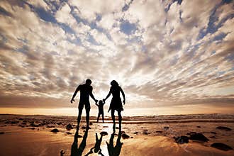 Happy family together hand in hand on the beach