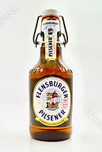 A bottle of German pilsener style beer isolated against a white background.