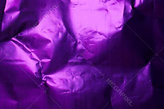 Crumpled purple foil creating unique textures and patterns under soft light in a compact space