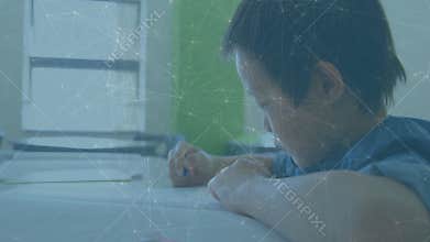 Schoolchild pressing blue crayon to paper, practicing fine line drawing on tabletop in study corner