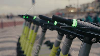 Row of Electric Scooters Lined Up on City Street for Urban Transportation