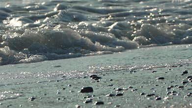 Waves, Beach, Sand - Closeup view of foamy ocean waves crashing on a sandy beach.