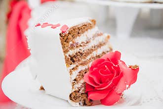 ake slice of delicious traditional sweet cake on a metal cake spatula in female hand on rose background . Napoleon cake