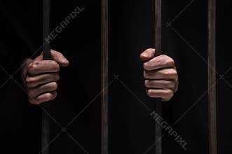 Closeup on hands of man sitting in jail.