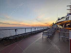 At sea 2025.09.13. - Open deck with sunbeds and chairs during sunset onboard a cruise ship