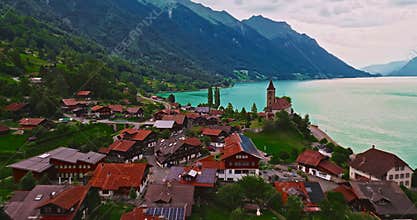 Aerial view of traditional Swiss houses rooftops on the shore of a lake between the Alps in Brienz, Switzerland