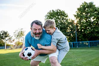 Dad and son sharing passion for football and active lifestyle.