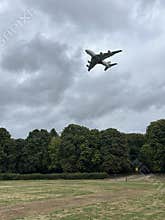 Commercial Airplane Flying Over Amsterdam Forest Under Cloudy Sky Netherlands