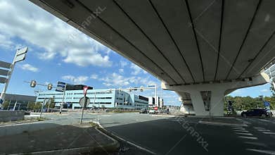 Elevated highway crossing above modern office district intersection with glass