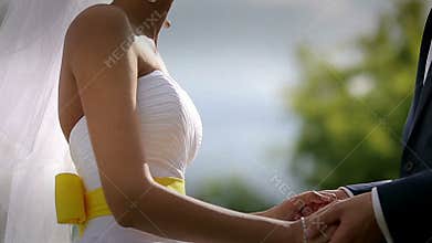 The bride and groom take each other's hands at sunset. Slow motion