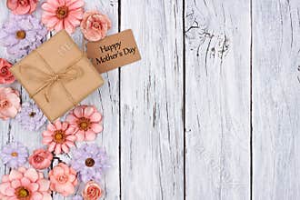 Paper flowers side border with Mother`s Day gift and tag over wood