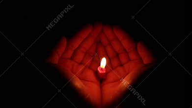 Candle In Hands On Black Background
