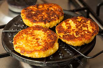 Corn breads being roasted on a round grill