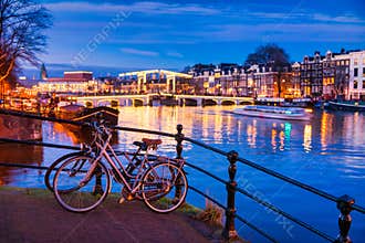 Skinny bridge and Amstel river in Amsterdam Netherlands at Dusk
