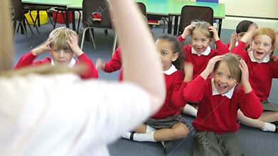 Pupils Copying Teacher's Actions Whilst Singing Song