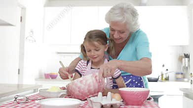 Grandmother And Granddaughter Baking In Kitchen