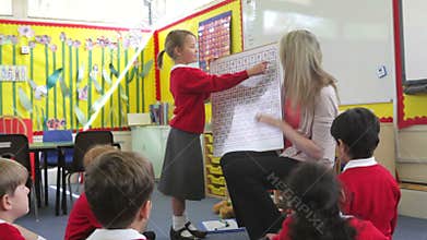 Teacher With Elementary School Pupils In Maths Lesson