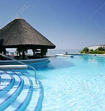 Tiki hut and bar by swimming pool of luxury hotel
