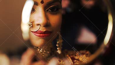 Indian bride looks at her reflection in the mirror