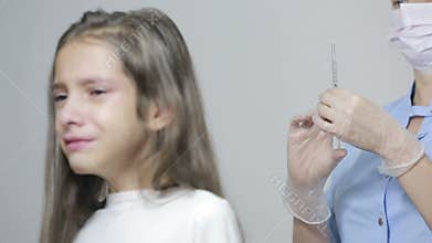 Little girl is afraid of the doctor with a syringe. baby cries afraid injection