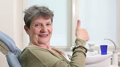 Close up of elderly woman giving thumbs up at dental ordination