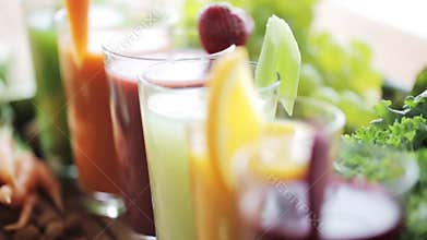 Glasses of juice, vegetables and fruits on table