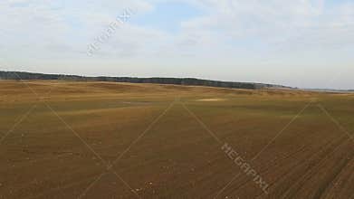 4K. Flight and takeoff above freshly cultivated fields in spring, aerial view.